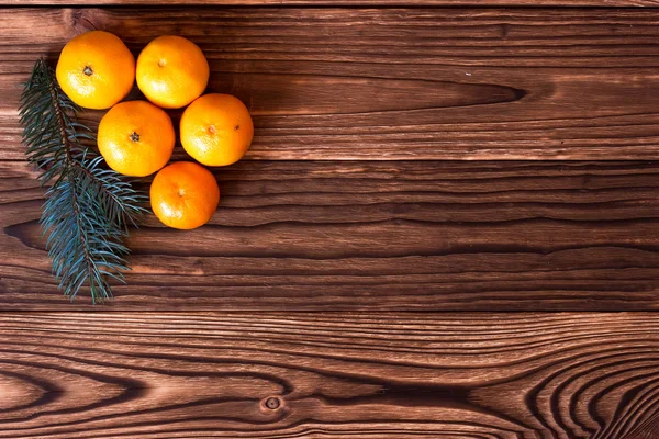 Noel ve yeni yıl mandalina yanındaki ahşap arka plan üzerinde koniler ile Noel ağacı dalları