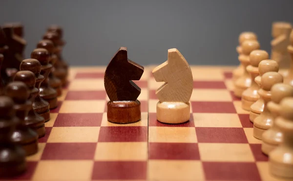 Tablero de ajedrez de madera y piezas sobre fondo negro — Foto de Stock