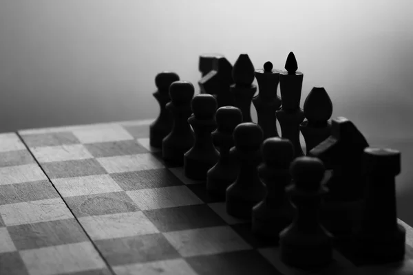 Дерев'яна шахова дошка і шахова фігура чорний силует — стокове фото