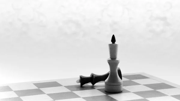 Black white chess board and pieces scattered on the board on the black white background — Stock Photo, Image