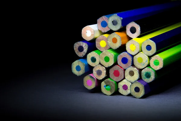 Colored pencils on a black background shadow — Stock Photo, Image