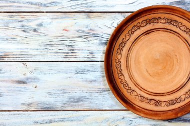 Beyaz tahtaların eski ahşap zemininde geleneksel Ukrayna desenli boş kil tabağı. Üst Manzara. Kopyalama alanı