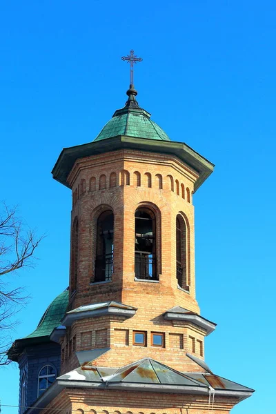 Ancient bell tower of a church. Church tower from the red brick on blue sky background
