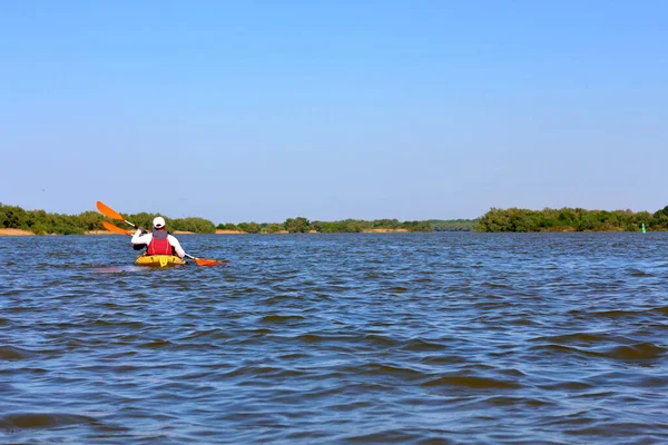 Yazın Tuna nehrinde iki adam sarı bir kanoya biner.