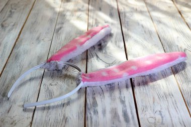 Beyaz ahşap arka planda pembe tavşan kulağı şeklinde saç halkası