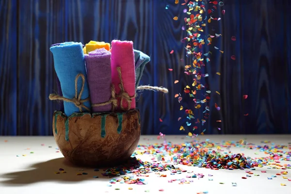 El yapımı seramik kasedeki bir iple bağlanmış çok renkli giysiler. Çok renkli konfetilerin hızlı uçuşu