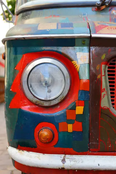 Yakın planda terk edilmiş boyanmış eski bir arabanın parçası. Farlar