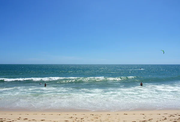 As pessoas nadam e brincam no mar, praia de areia e céu azul claro; Mui ne, Vietnã — Fotografia de Stock