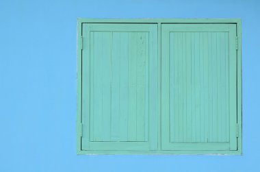 Mavi çimento duvarda yeşil ahşap pencere