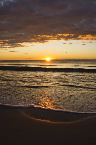 İspanya, Benicasim 'de bir sahilde bulutlu bir gün doğumu