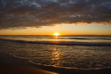 İspanya, Benicasim 'de bir sahilde bulutlu bir gün doğumu