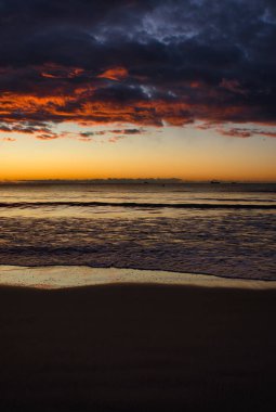 İspanya, Benicasim 'de bir sahilde bulutlu bir gün doğumu