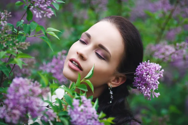 Mooi meisje in een park met bloemen boom — Stockfoto