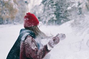 Kırmızı kulübede genç bir kız ve eldivenler karla el çırpıyor. Kış Konsepti.
