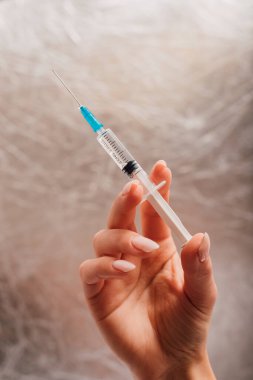 Doktor elinde bir şırınga tutuyor. Aşı, enjeksiyon.