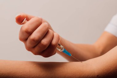 Şırıngayı tutan doktorların ellerini kapatın.