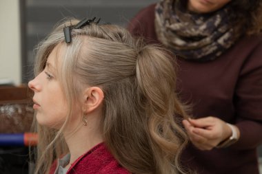 Profesyonel tarzda saçı ve doğal makyajı olan sakin bir kadının portresi. Tarafsız bir arkaplanda güzellik, özgüven, sağIık ve zarif yaşam tarzı kavramı.