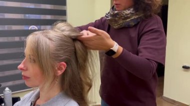 Modern bir güzellik salonunda kuaförden profesyonel saç stili alan bir kadın. Güzellik hizmeti, bakım ve kişisel bakım kavramı.