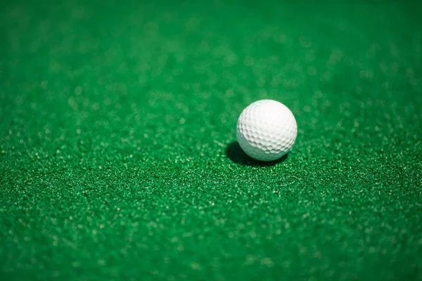 Bola de golfe num campo verde. Uma bola branca para golfe . — Fotografia de Stock