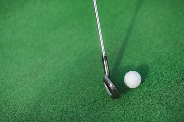 Golf club och bollen på en grön gräsmatta. slag mot en boll golf club. — Stockfoto