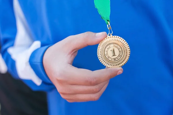 hand of the man and medal close up. the winner holds a medal.