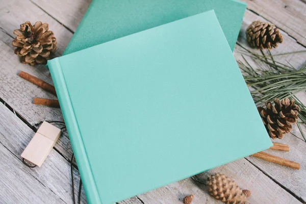 El libro azul sobre un fondo de madera con conos y canela . —  Fotos de Stock