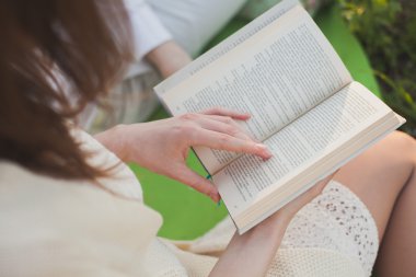 açık bir kitap tutan kadının el