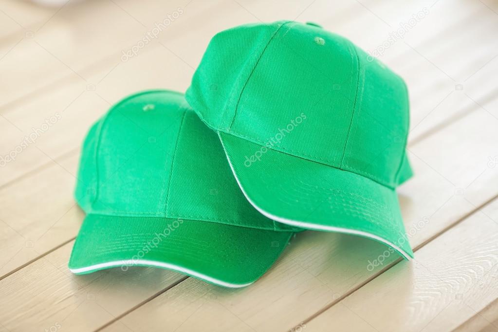 Two green baseball caps 