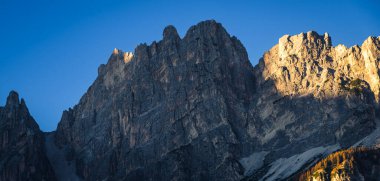 Dolomite Alpleri 'nin dağ zirveleri gün batımında gün ışığıyla aydınlanır..