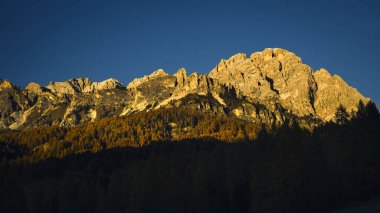 Dolomite Alpleri 'nin dağ zirveleri gün batımında gün ışığıyla aydınlanır..