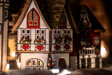 Seramik minyatür yarı keresteli evler, içeriden aydınlatılmış, Noel köyü süslemeleri olarak kullanılıyor..