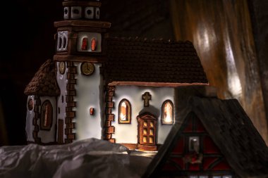 Seramik minyatür yarı keresteli evler, içeriden aydınlatılmış, Noel köyü süslemeleri olarak kullanılıyor..