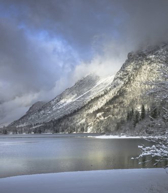 Çam ağaçları ve Predil Gölü, İtalya 'nın karla kaplı manzarası