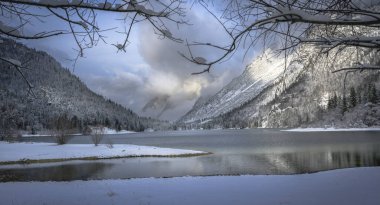 Çam ağaçları ve Predil Gölü, İtalya 'nın karla kaplı manzarası