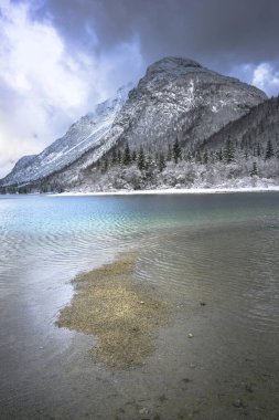 Çam ağaçları ve Predil Gölü, İtalya 'nın karla kaplı manzarası