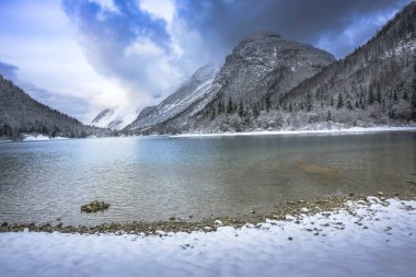 Çam ağaçları ve Predil Gölü, İtalya 'nın karla kaplı manzarası