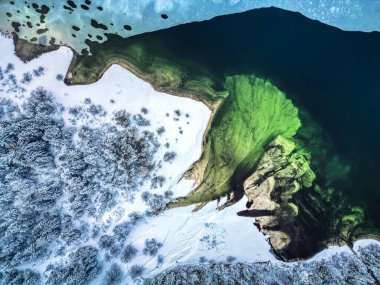 Su yakınında çam ağaçları bulunan karla kaplı hava manzarası, Predil Gölü, İtalya