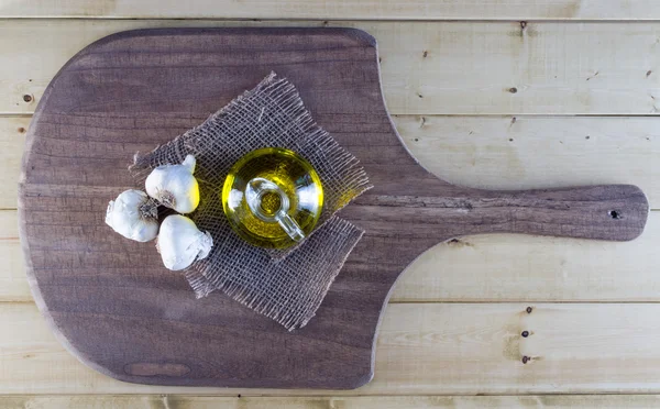 Garlic and Olive Oil on Rustic Board — Stock Photo, Image