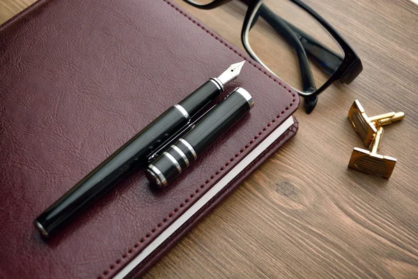 stock image Business accessories on desktop: notebook, diary, fountain pen, cufflinks, glasses. 