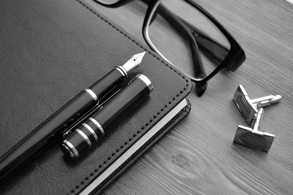 Деловые аксессуары на рабочем столе: ноутбук, дневник, авторучка, запонки, очки . — стоковое фото