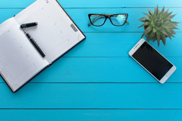 Ofis resepsiyon masası dizüstü bilgisayar, smartphone, kalem, kurşun kalem ve defter. Düz yatıyordu fotoğraf. Üstten Görünüm kopya alanı ile. Ofis, banka donatımı ve gadget'lar Resepsiyon masasında. Çalışma Resepsiyon Masa kavramı.