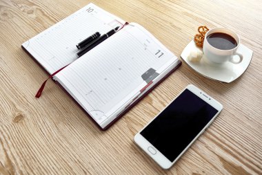 Açık defter, ahşap masa kahve ile telefon