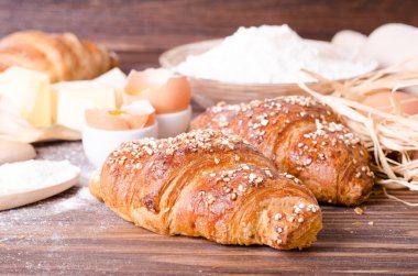 Malzemeler kruvasan - kağıt, un, tahta kaşık, oklava, yumurta pişirme için yumurta sarısı, tereyağı bir rustik ahşap tepsi masaya servis. 