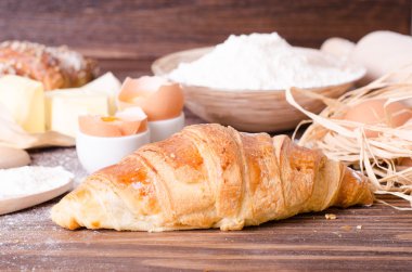 Malzemeler kruvasan - kağıt, un, tahta kaşık, oklava, yumurta pişirme için yumurta sarısı, tereyağı bir rustik ahşap tepsi masaya servis. 