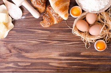 Malzemeler kruvasan - kağıt, un, tahta kaşık, oklava, yumurta pişirme için yumurta sarısı, tereyağı bir rustik ahşap tepsi masaya servis. 