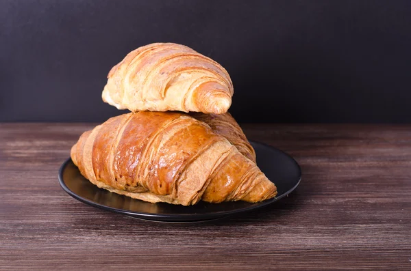 Fresh croissants on wooden background. Free space for your text. — Stock Photo, Image