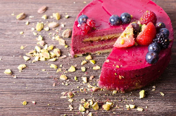 Délicieux gâteau aux framboises fraîches, framboises, bleuets, groseilles et pistaches sur fond de bois . — Photo