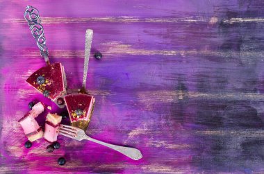 Taze ahududu, yaban mersini, kuş üzümü ve kürek, parlak mor, violet arka plan üzerinde Antep fıstığı ile lezzetli frambuazlı pasta parçası. Metniniz için boş alan.