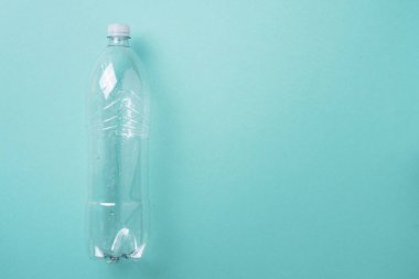 Mavi arka planda plastik şişeler. Üst Manzara. Plastik geri dönüşümü, atık kirliliği konsepti. Üst görünüm, boşluğu kopyala. Çevre koruma kavramı. Çöpü tekrar kullan, plastiksiz. Dünya, dünya su günü.