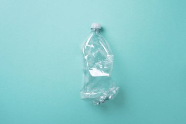 Mavi arka planda kırışık kullanılmış plastik şişe. Üst görünüm, boşluğu kopyala. Kirlilik, çevre koruma kavramı. Çöpü, geri dönüşümü, plastiği yeniden kullan. Dünya, dünya su günü.